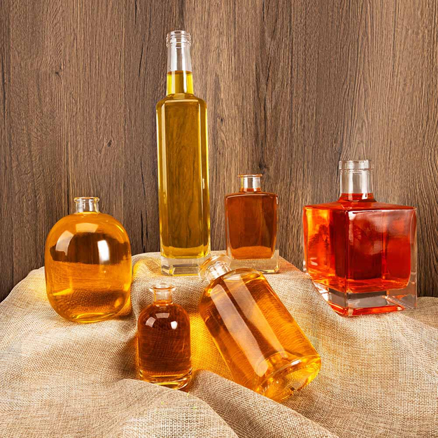 W zaopatrzonych przezroczystych kwadratowych okrągłych szklanych butelkach na alkohol